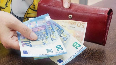 main avec trois billets de vingt euros et un billet de cinquante euros